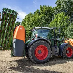 Zielony traktor z opryskiwaczem, gotowy do pracy w polu. Gdzie zrobić atest na opryskiwacz? Tutaj znajdziesz odpowiedzi.