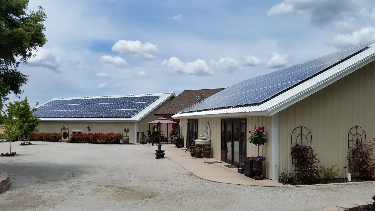Budynki z panelami słonecznymi na dachach, symbolizujące odnawialne źródła energii.